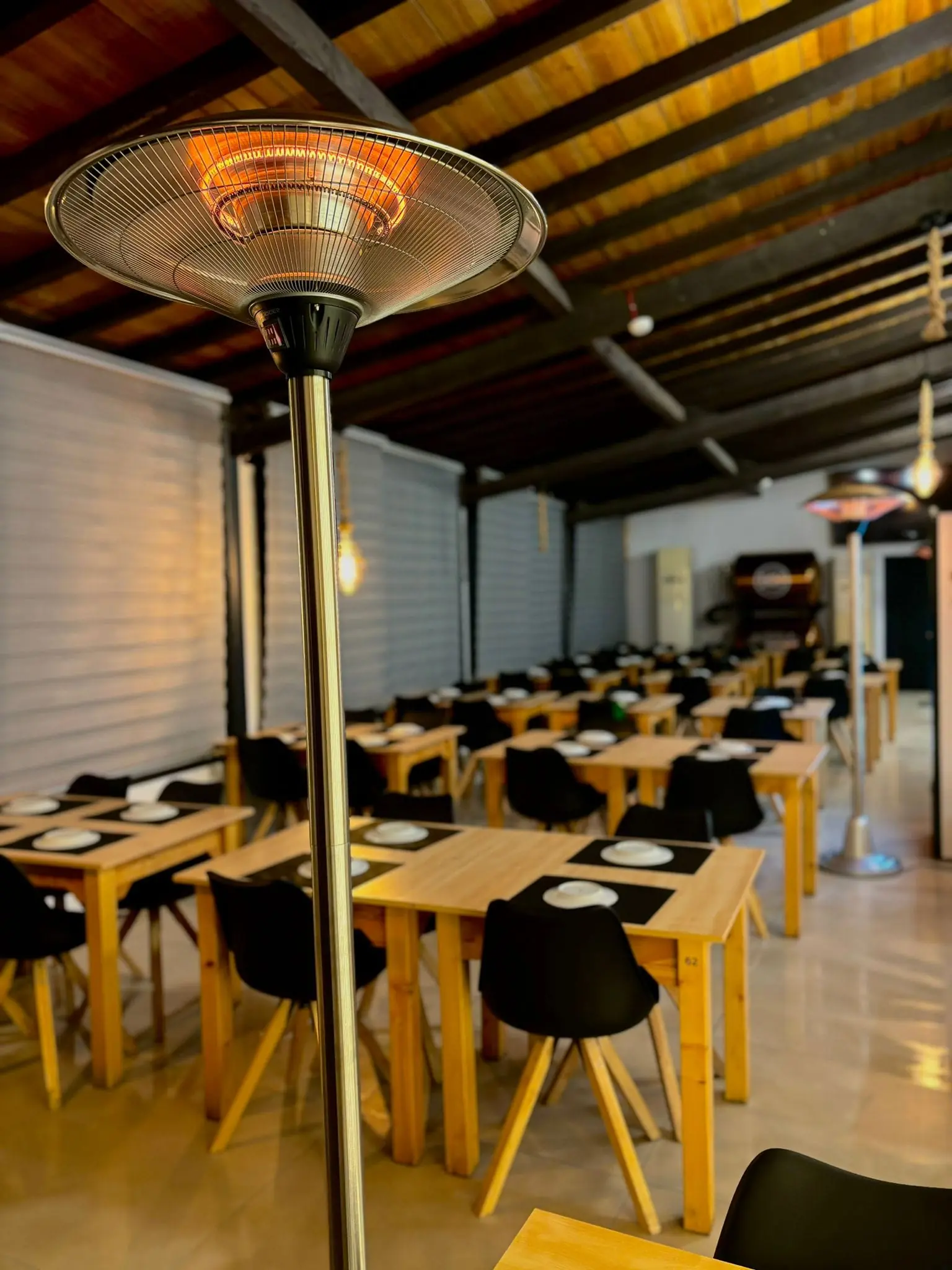 Espaço coberto com mesas para jantares